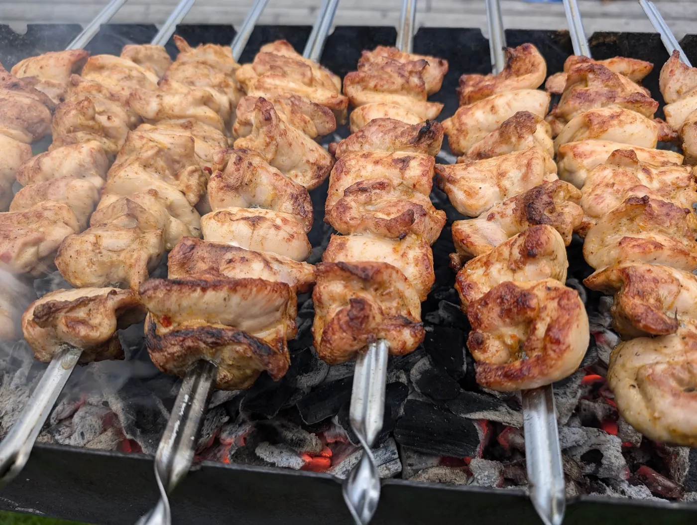 Goldbraune Schaschlikspieße auf einem Holzkohlegrill