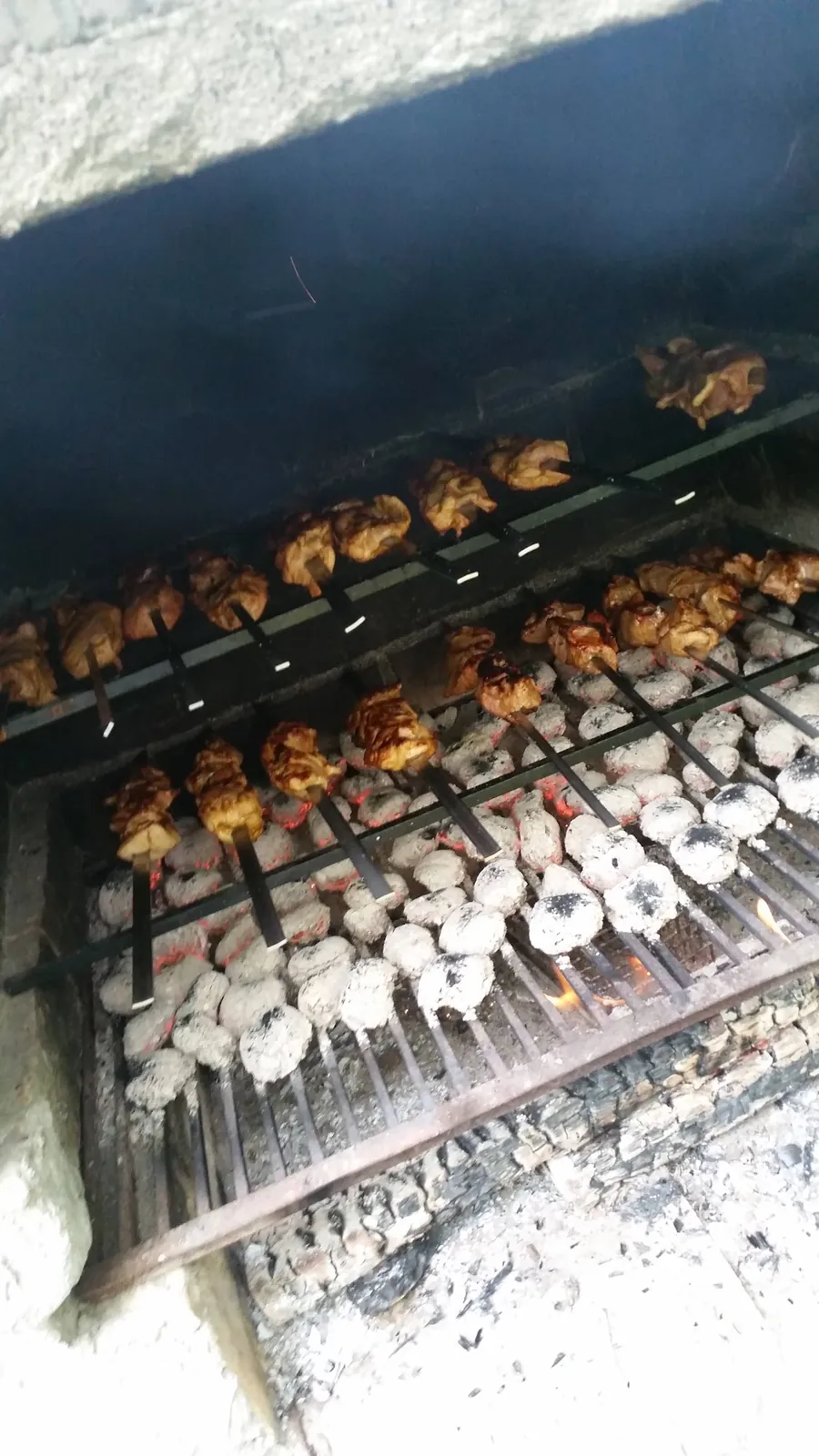 Schaschlikspieße auf einem gemauerten Grill